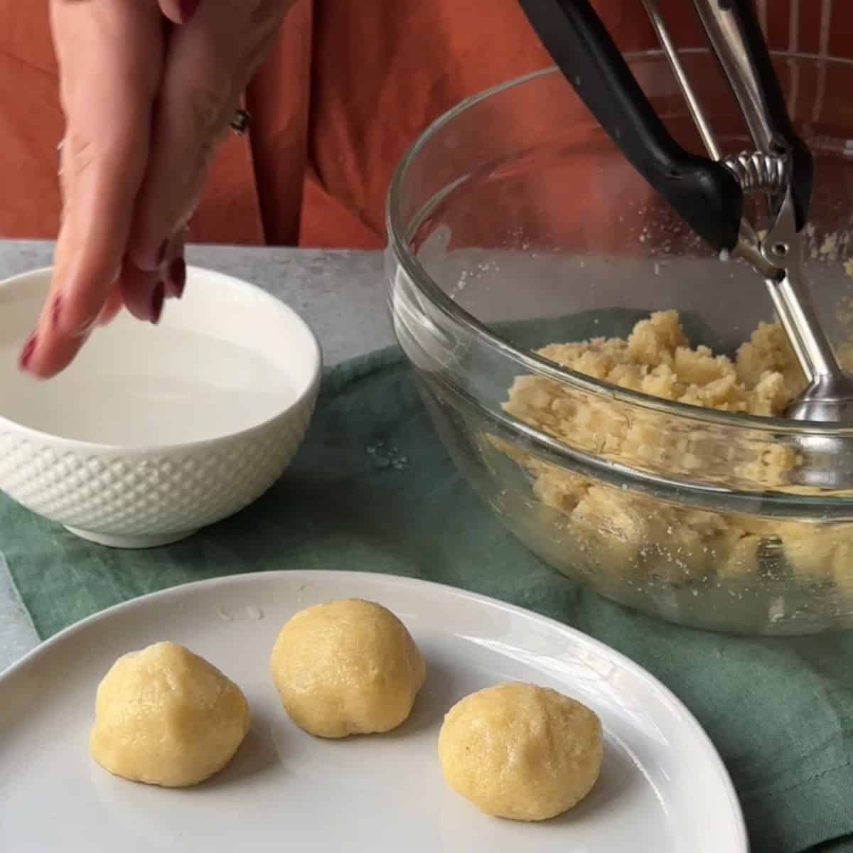 How to Make Amaretti Cookies with wet hands, form the amaretti dough into balls