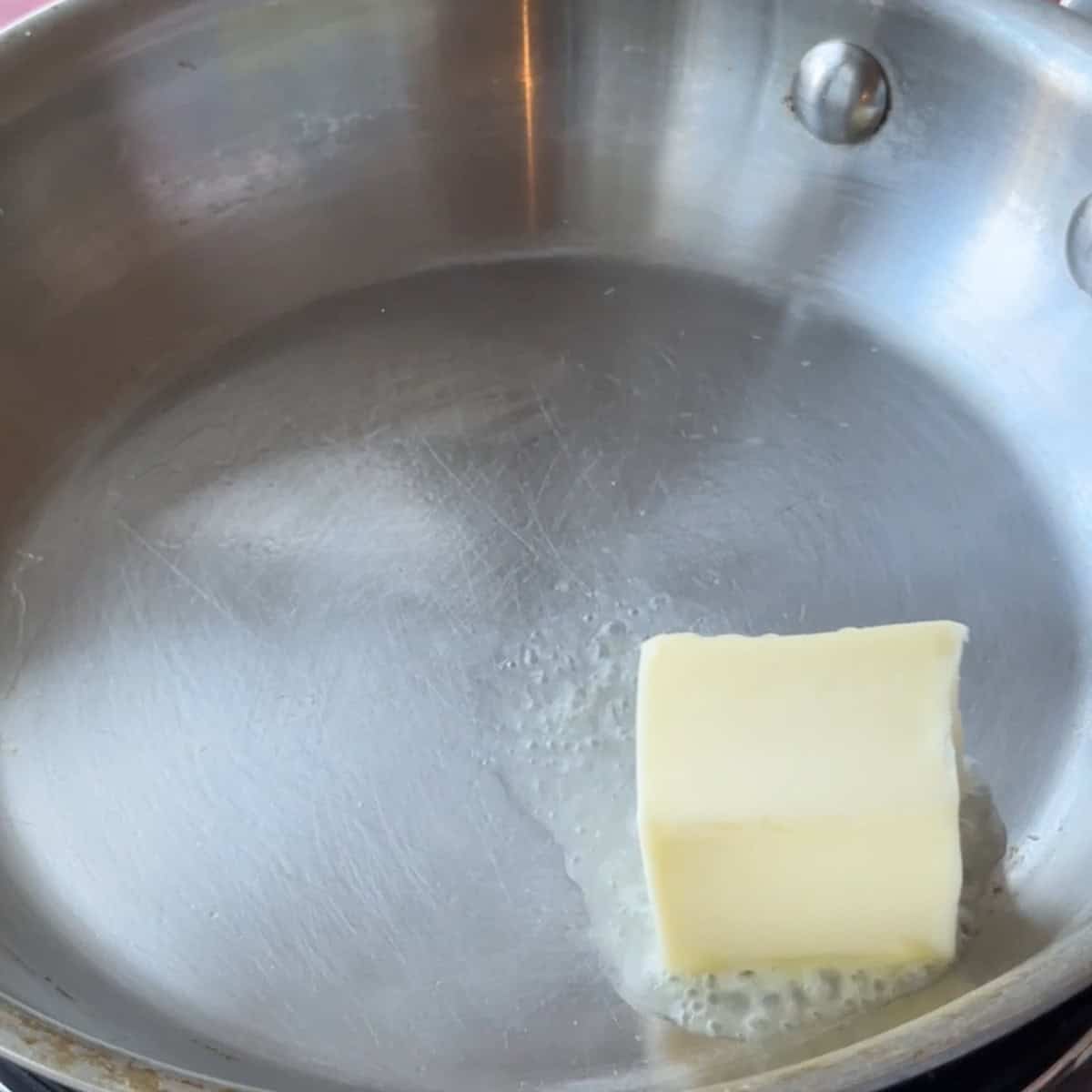 Adding butter to a pan.