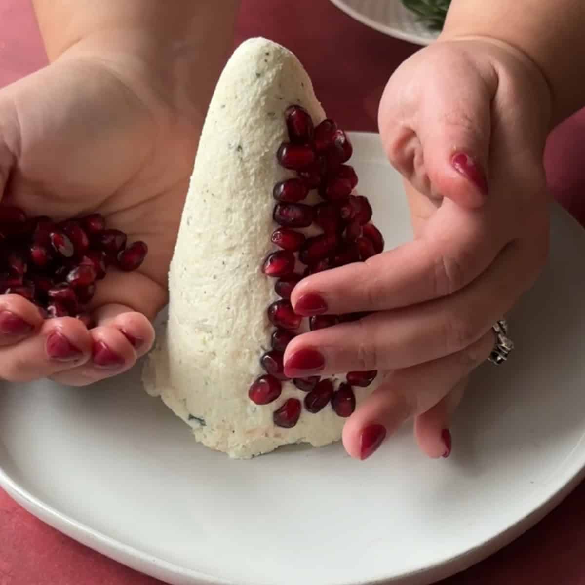How to Make Christmas Tree Cheese Ball start covering cheese "tree" with pomegranate arils
