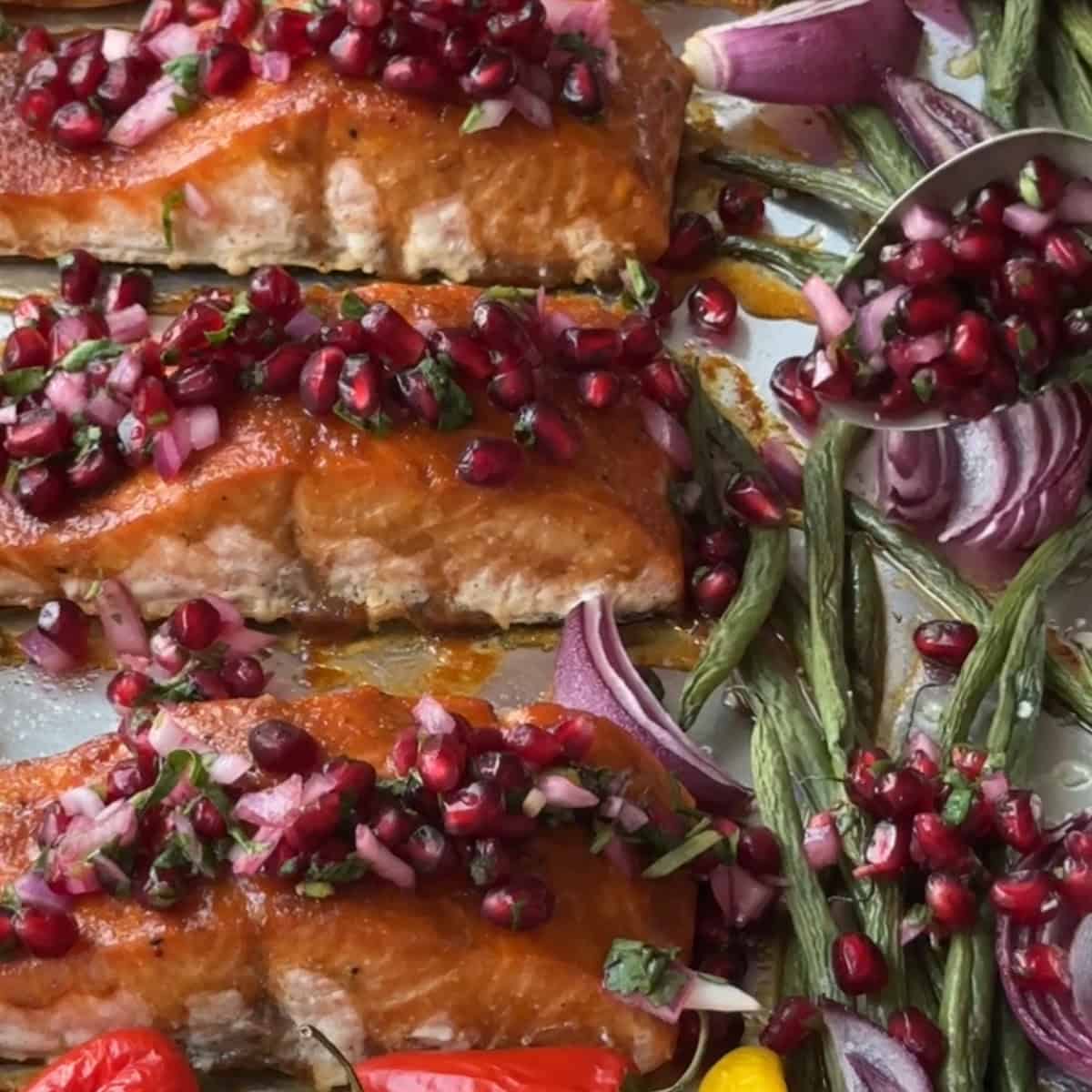 add the pomegranate salsa on top of the sheet pan salmon