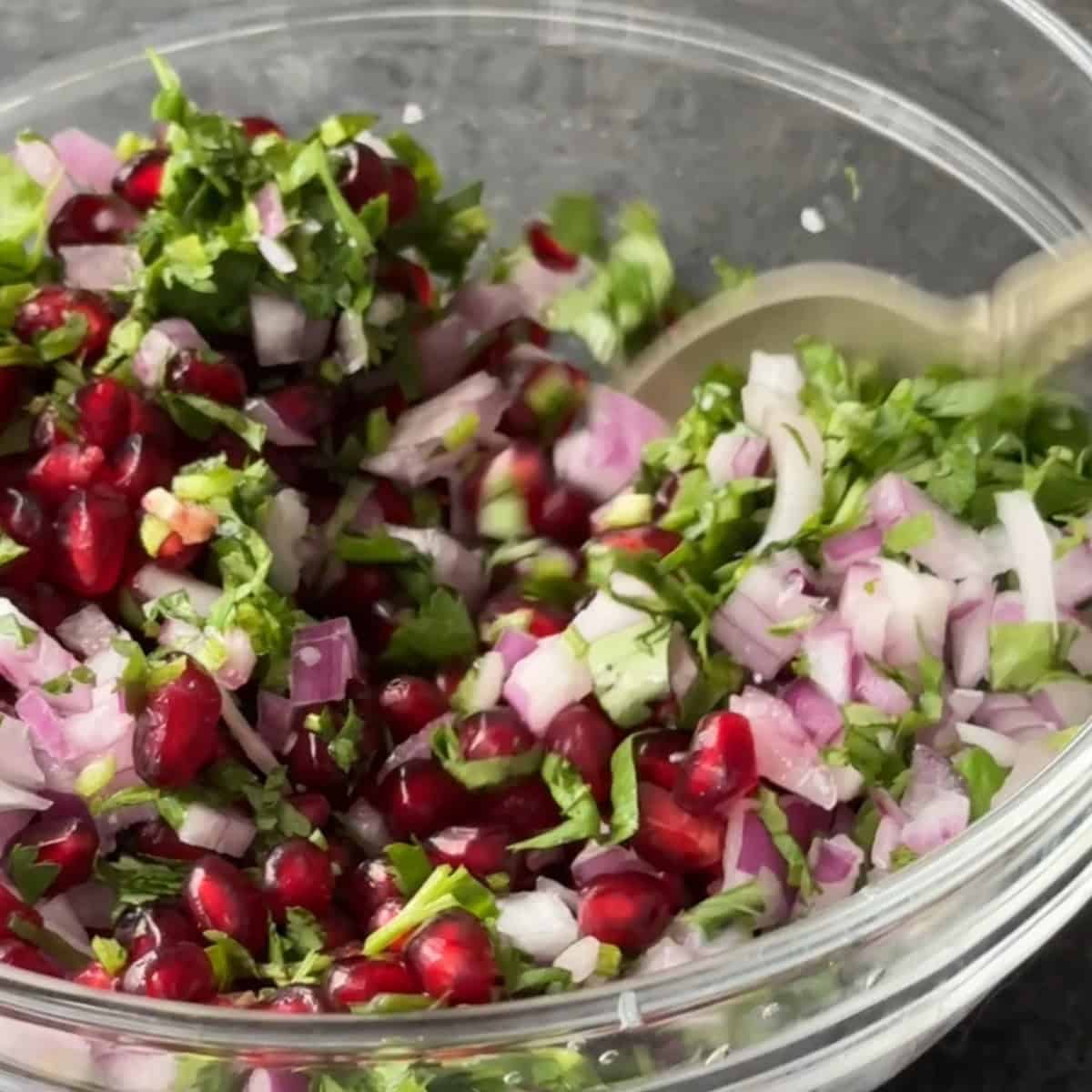 add finely diced onions and cilantro to bowl with pomegranate arils