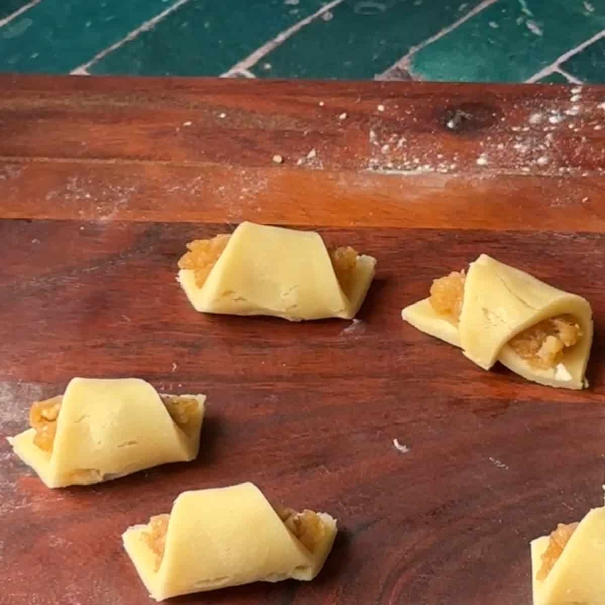 How to Make Turkish Apple Cookies roll dough into crescent or croissant shape to close over the filling