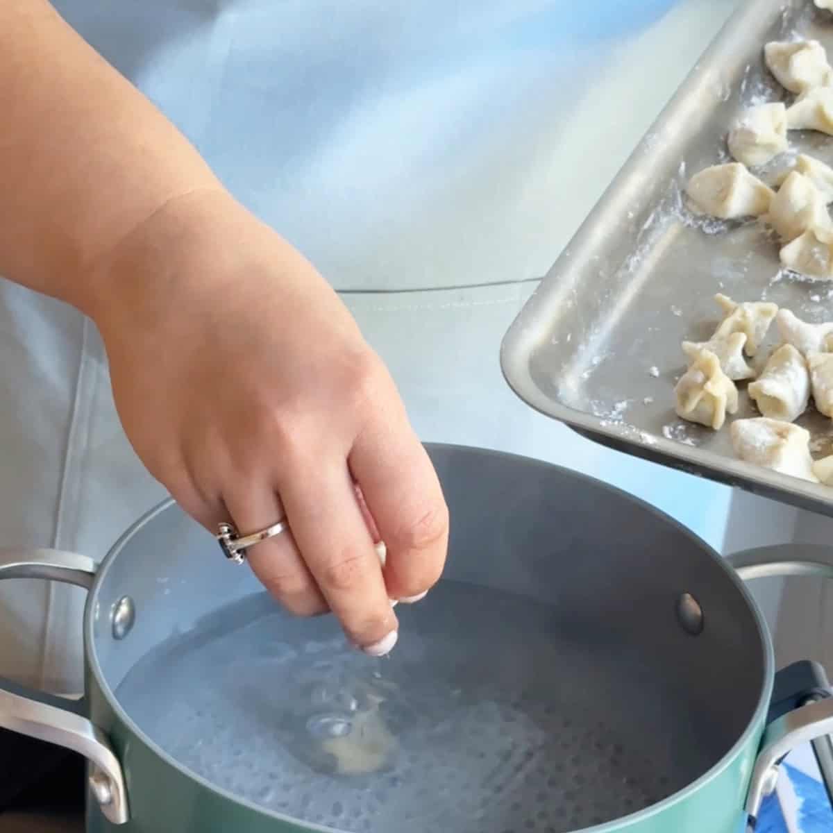 How to Boil Manti A large pot of salted boiling water with manti being gently dropped in for cooking