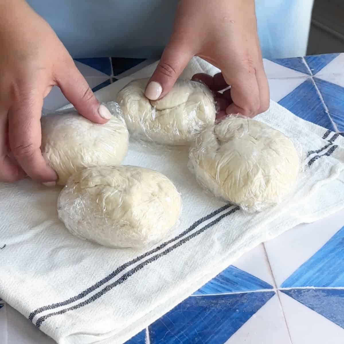 Turkish Dumplings Dough four pieces of dough wrapped in plastic wrap ready to rest