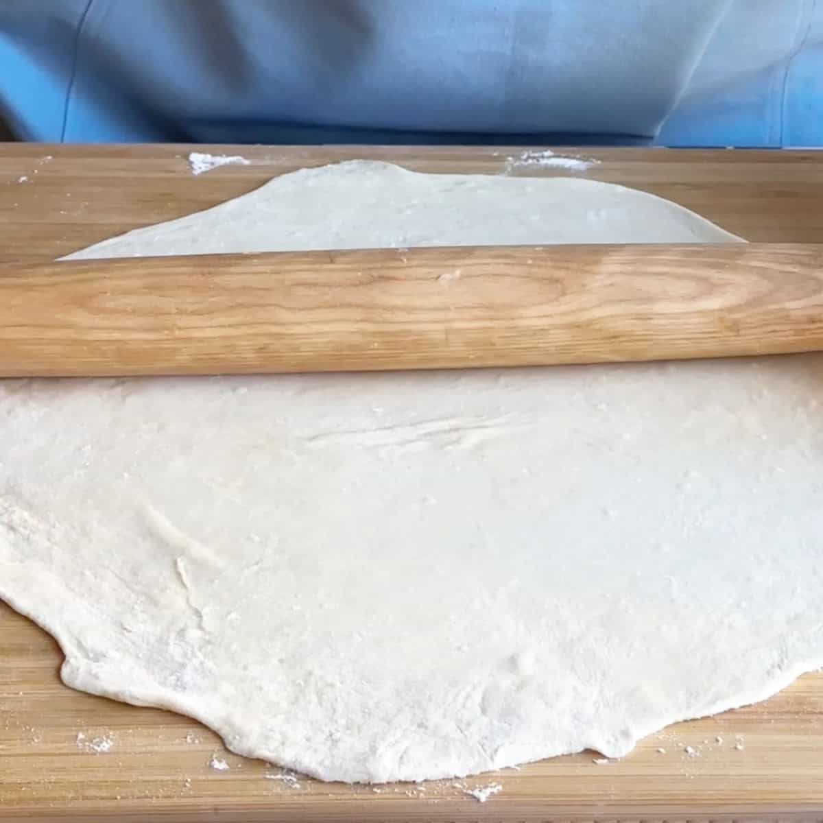 A rolling pin flattening the dough to about 1/16-inch thickness for delicate manti dumplings