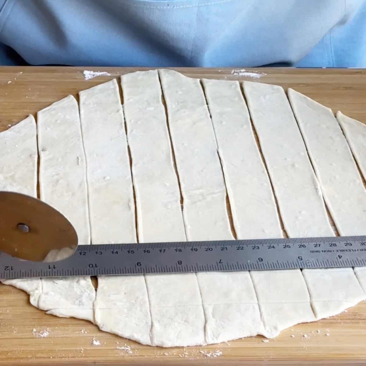 How to Cut Manti Dough Dough sheet being cut into uniform 1-inch squares using a pastry cutter