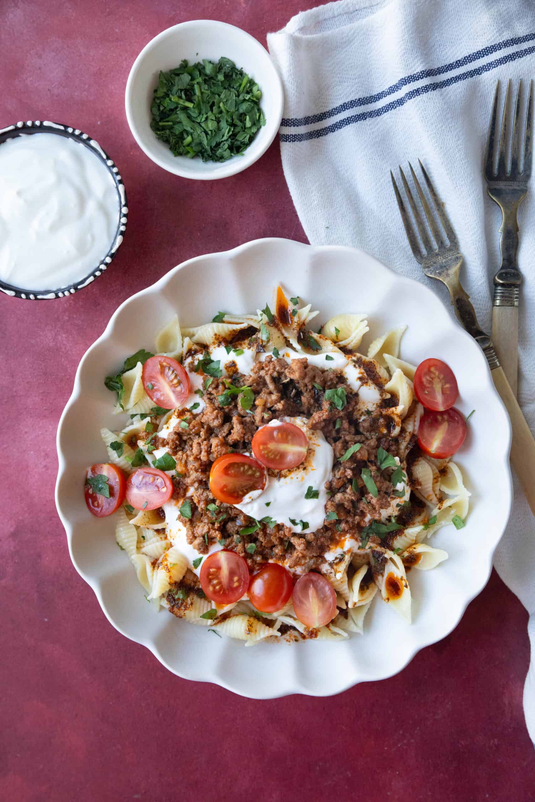 Turkish Pasta Recipe A bowl of Turkish pasta topped with spiced ground beef, creamy garlic yogurt, and a drizzle of buttery paprika sauce.