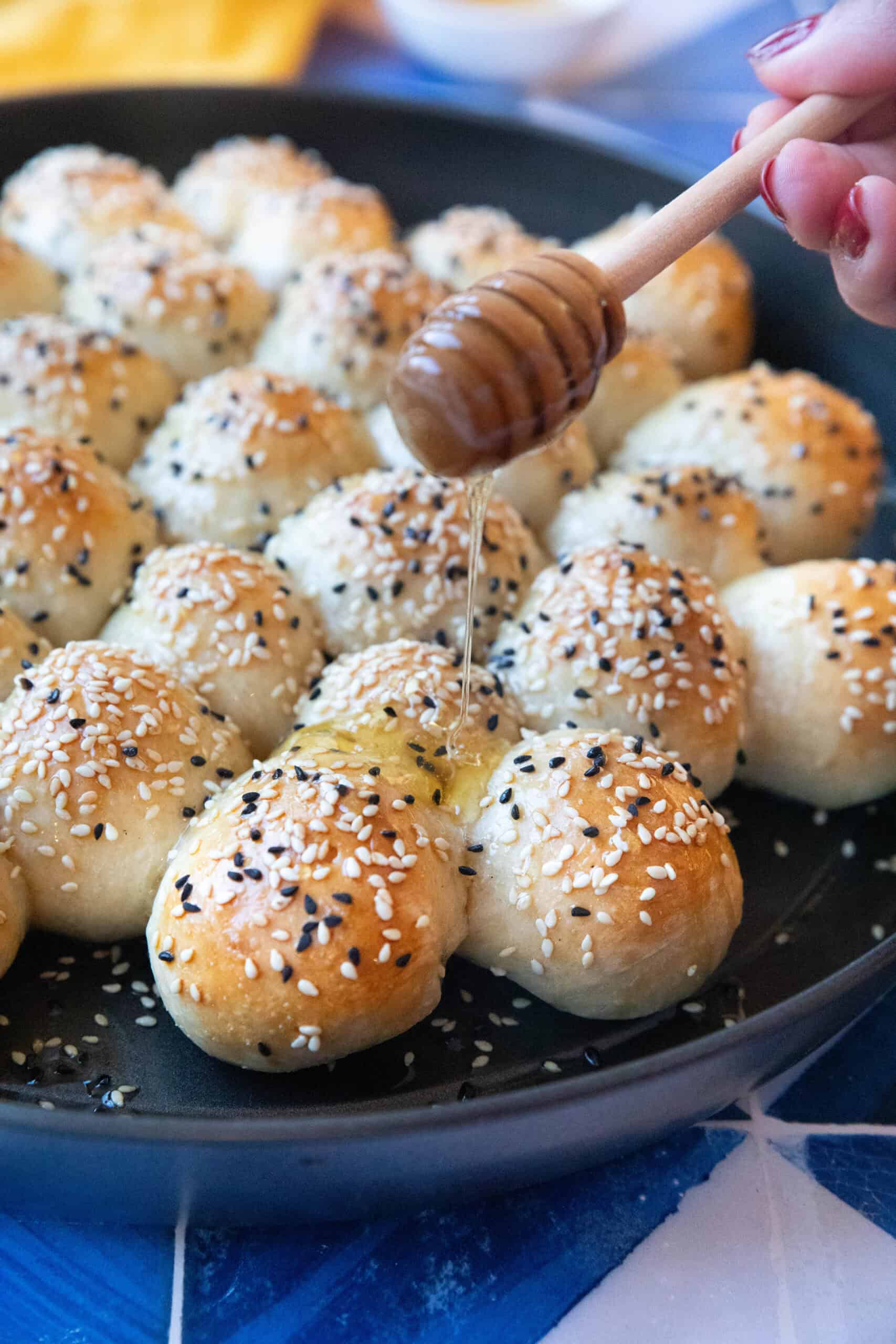 Honeycomb Bread with Honey Freshly baked honeycomb bread with a golden crust, drizzled with honey and sprinkled with sesame and nigella seeds, served warm.
