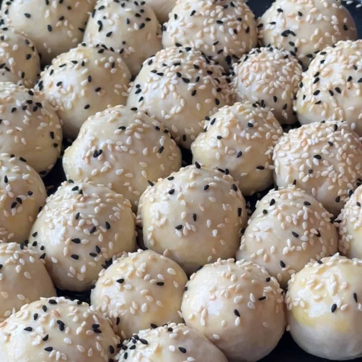 sprinkling nigella seeds o the honeycomb dough before placing it in the oven