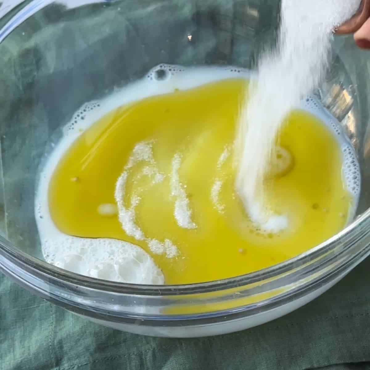 adding sugar and yeast to the water and milk mixture