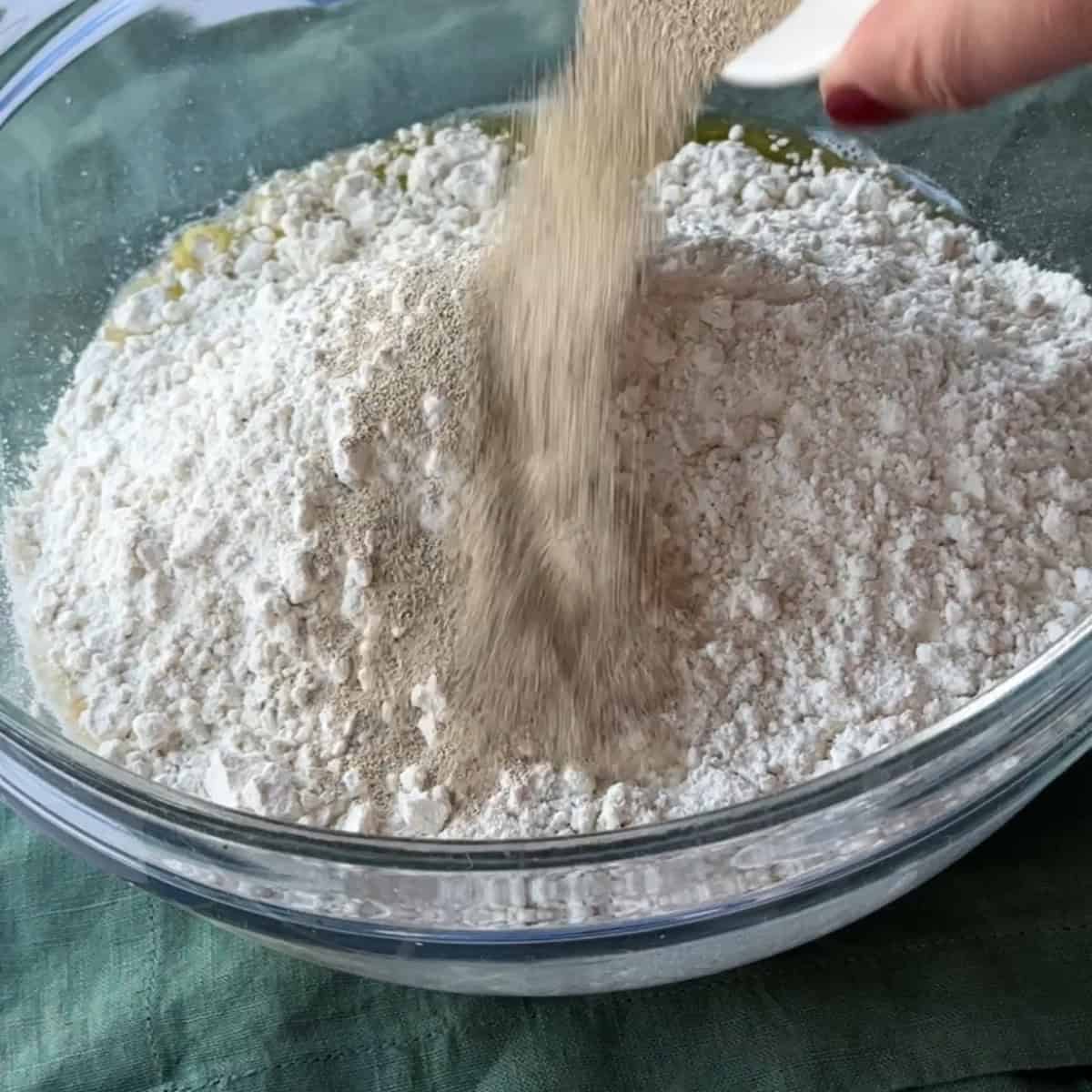 adding yeast to the flour and wet ingredients