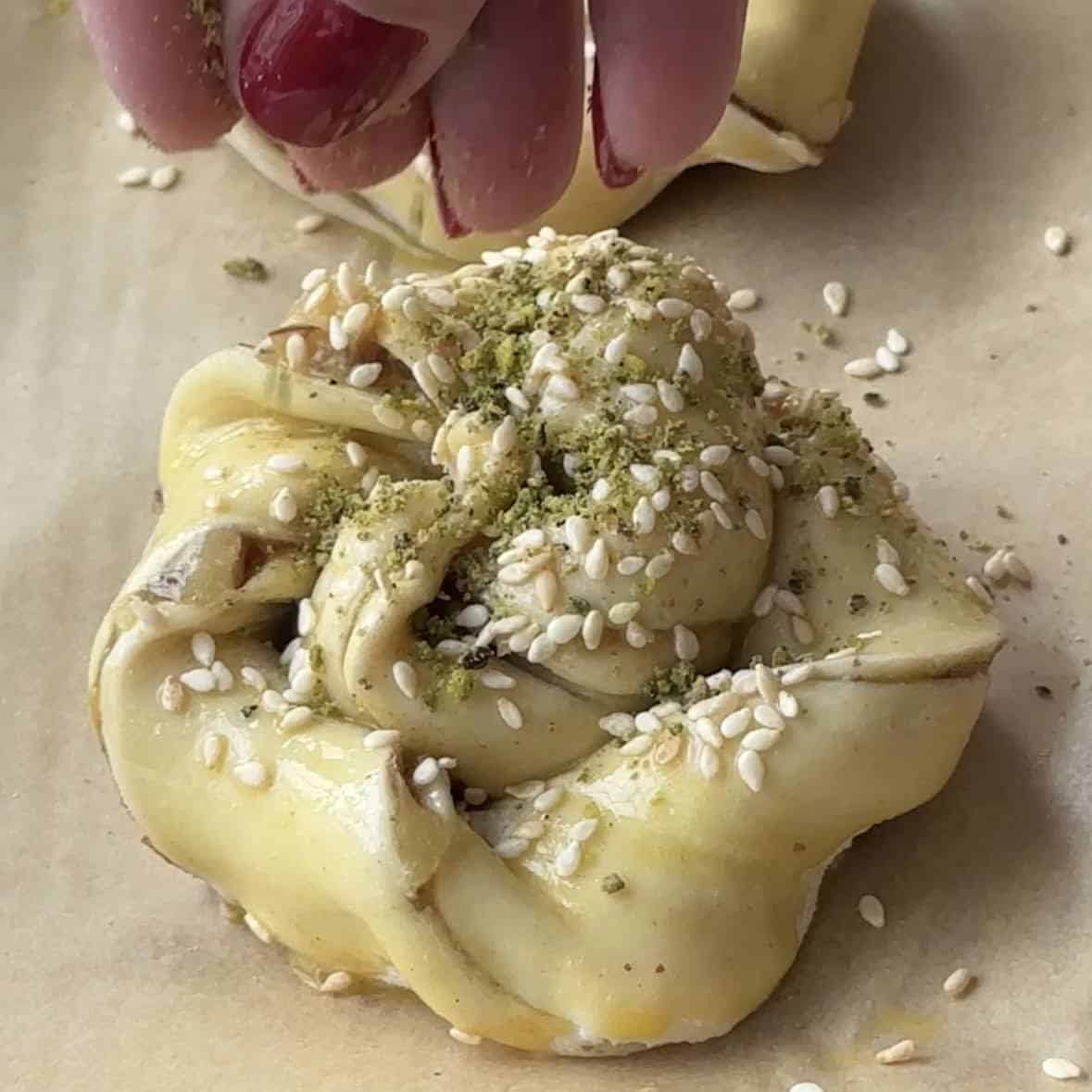 top with egg wash, sesame seeds and pistachio