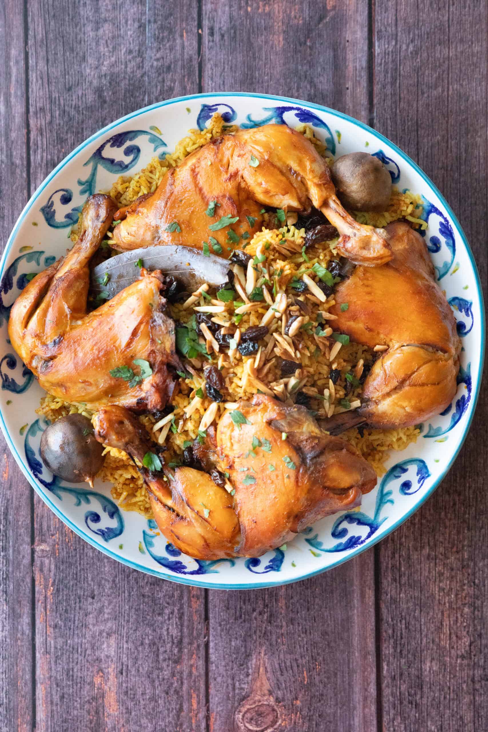 beautifulyl plate machboos chicken on rice with raisin and almond garnish