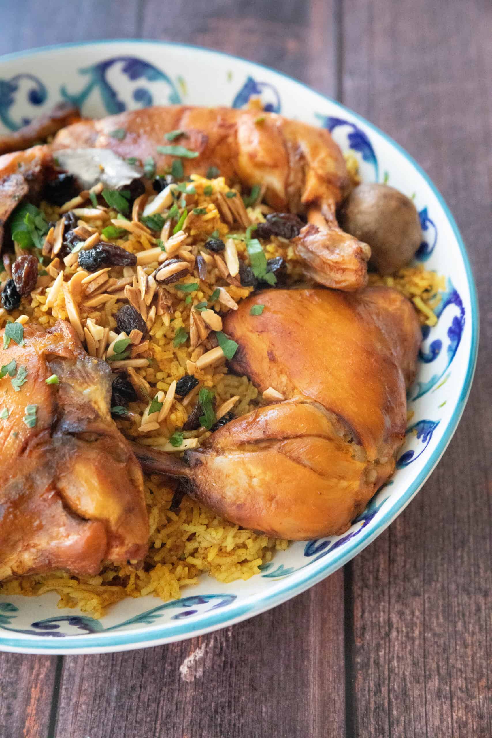 Kabsa Chicken and Rice machboos or kabsa (a chicken and rice dish from the Middle East) served in a decorative bowl with garnish