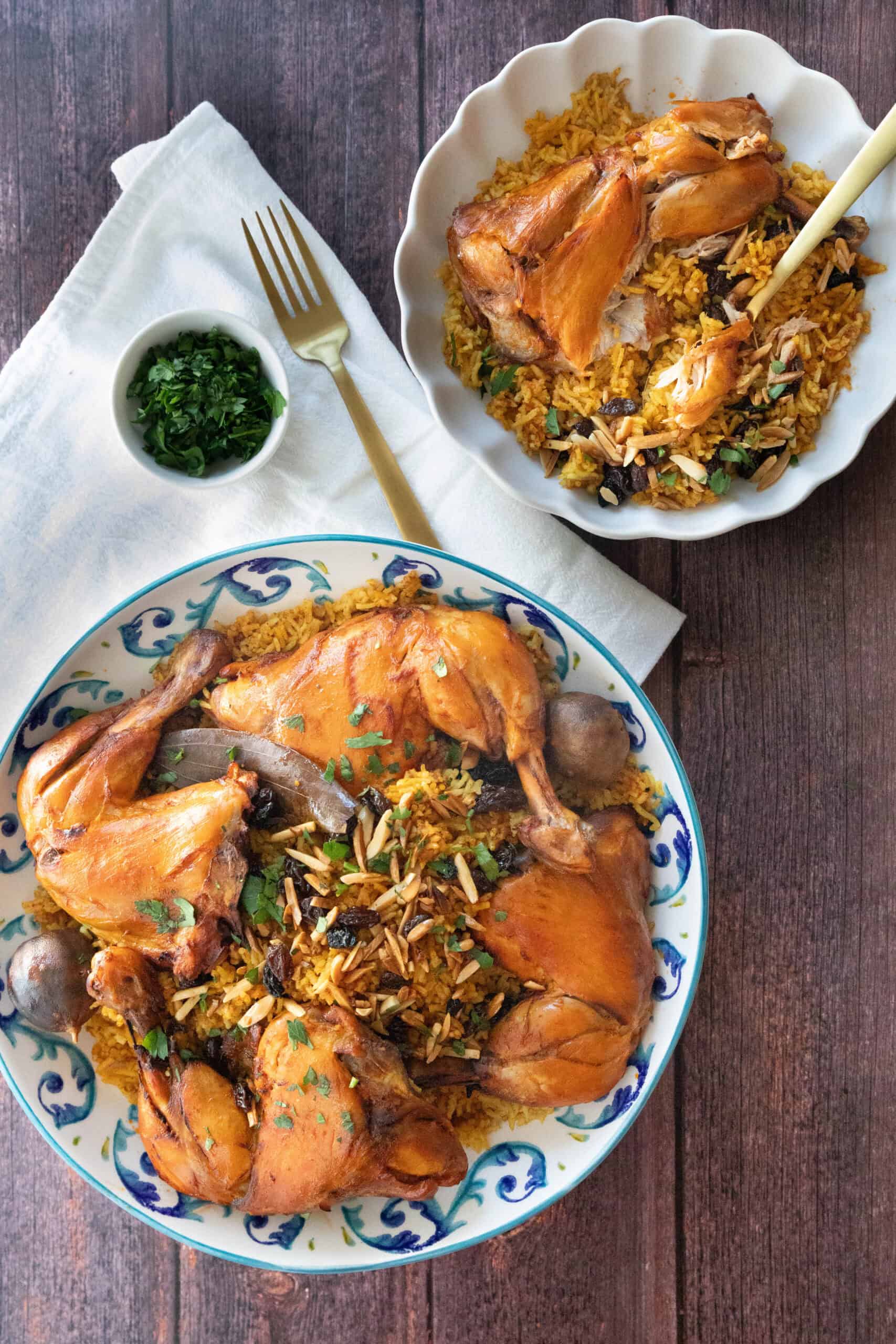 Machboos (Kabsa Chicken and Rice) machboos served in a larger decorative bowl and a smaller single serving dish with some garnish