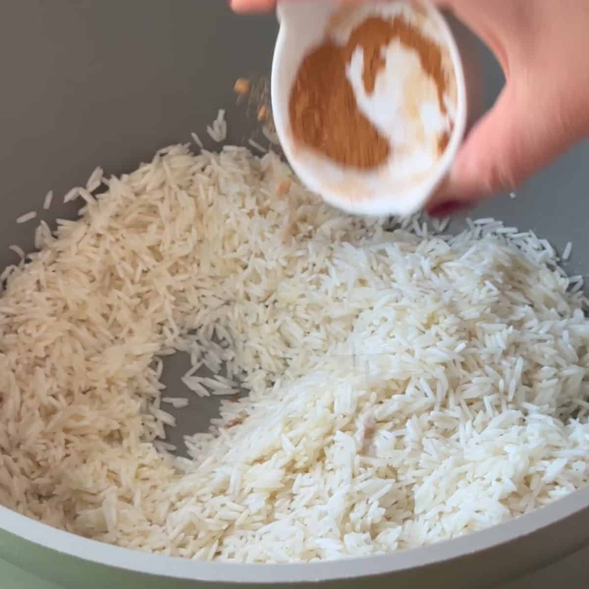 How to Make Machboos add rice to pot and start adding spices