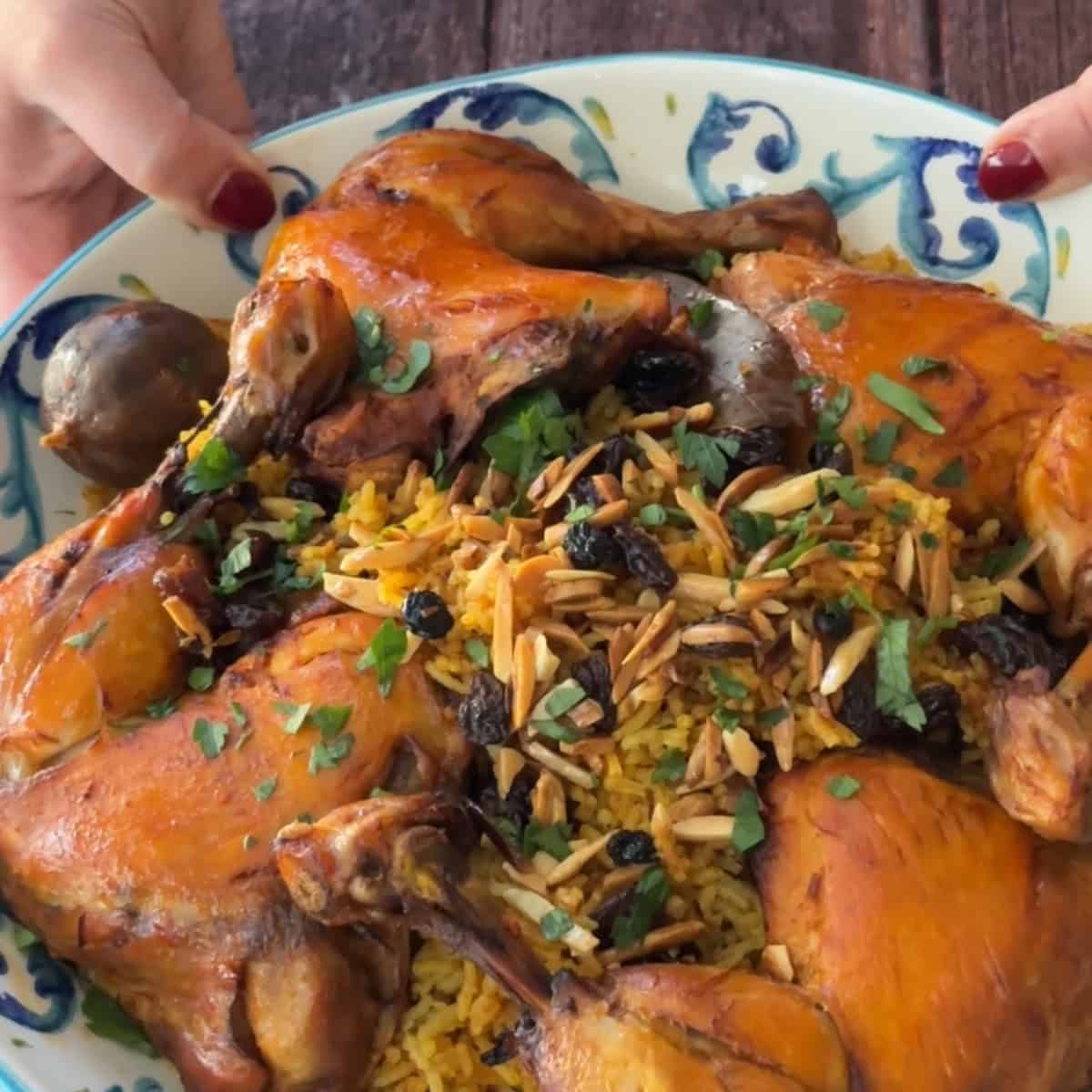 How to make machboos Machboos, or Kabsa, Chicken and Rice served in a decorative bowl garnished with raisins and slivered almonds