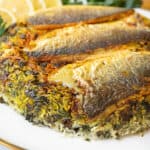 A golden, crispy fish tahdig flipped onto a serving platter, revealing its perfectly crunchy crust.