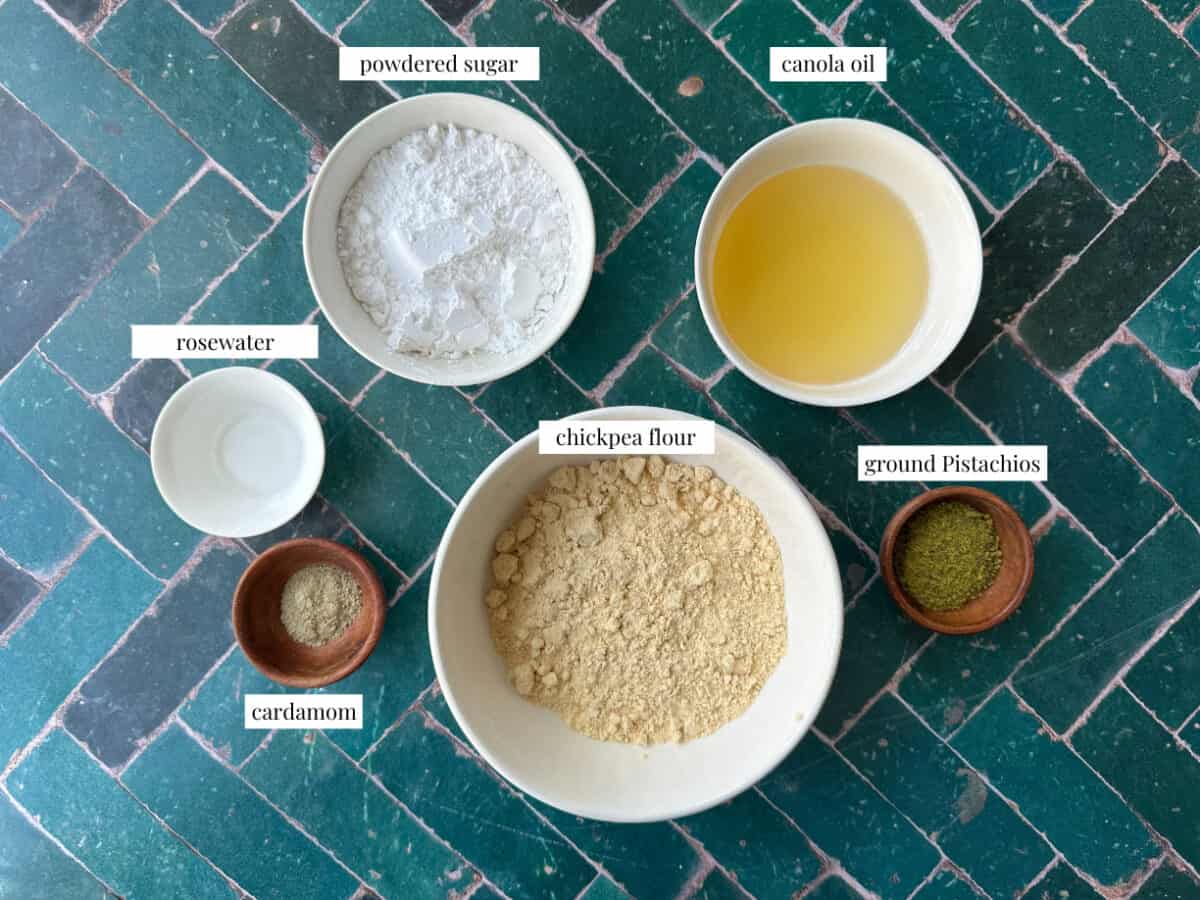 Naan Nokhodchi A neatly arranged display of ingredients for Nan-e Nokhodchi, including chickpea flour, powdered sugar, butter, cardamom, and rosewater.