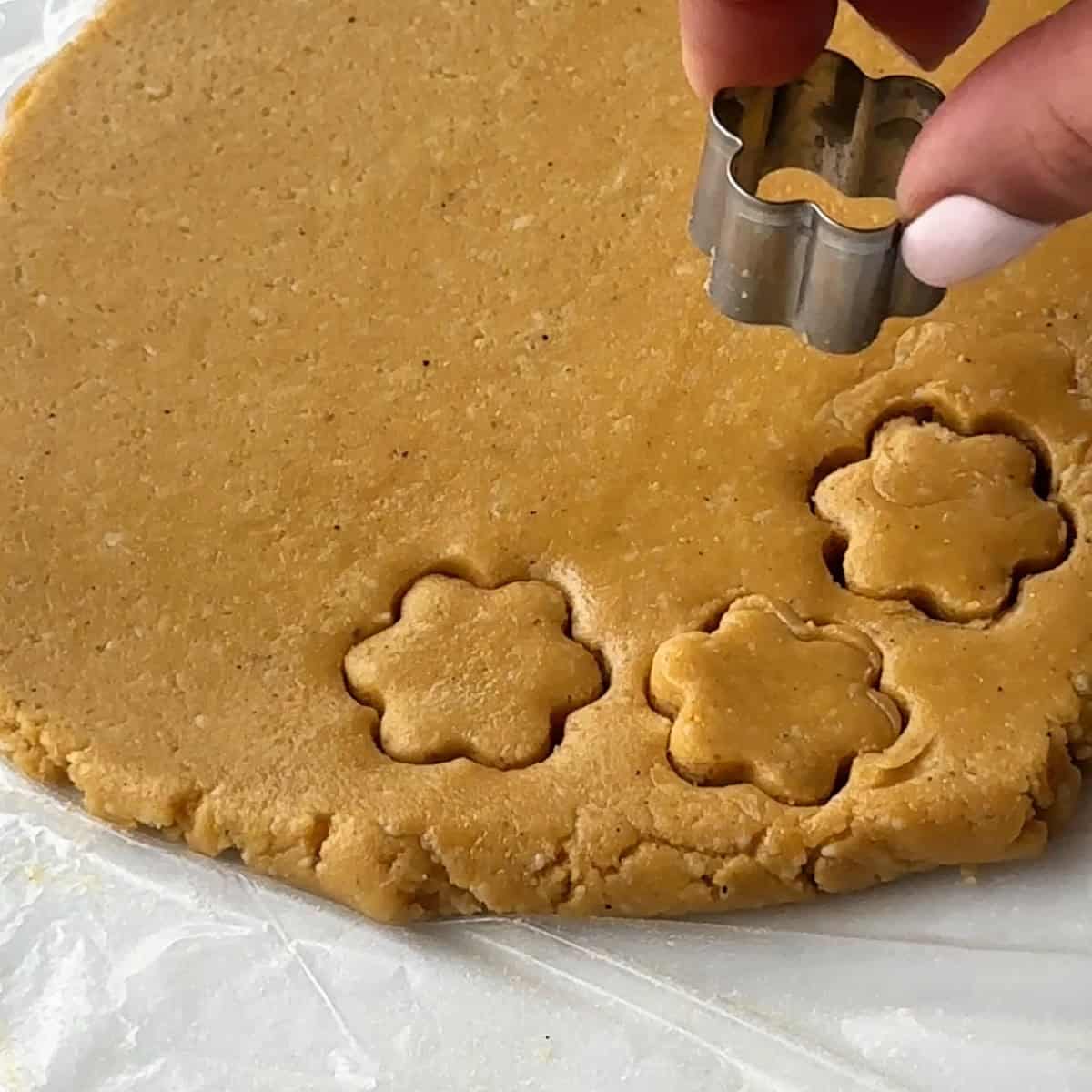 Iranian New Year desserts cutting nokhodchi dough with a cookie cutter into a flour shape