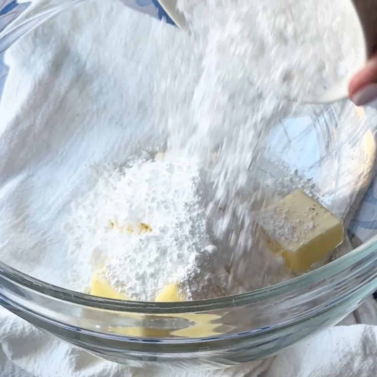 In a large bowl, add powdered sugar to the unsalted butter
