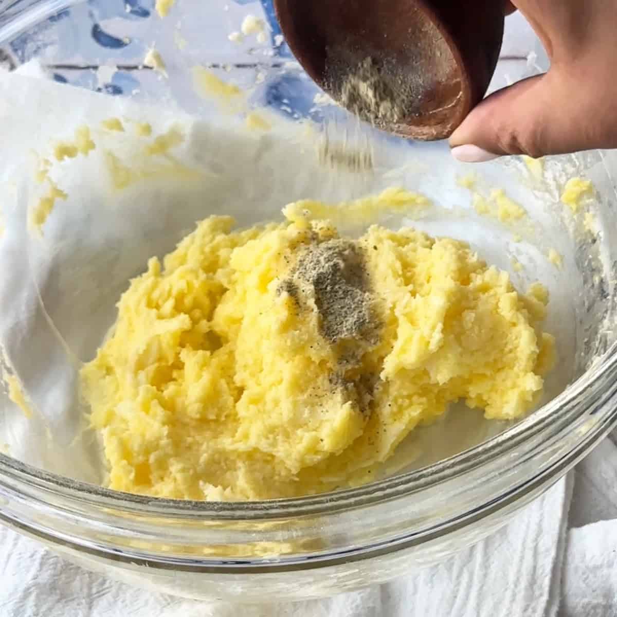 adding ground cardamom to the buttery cookie dough