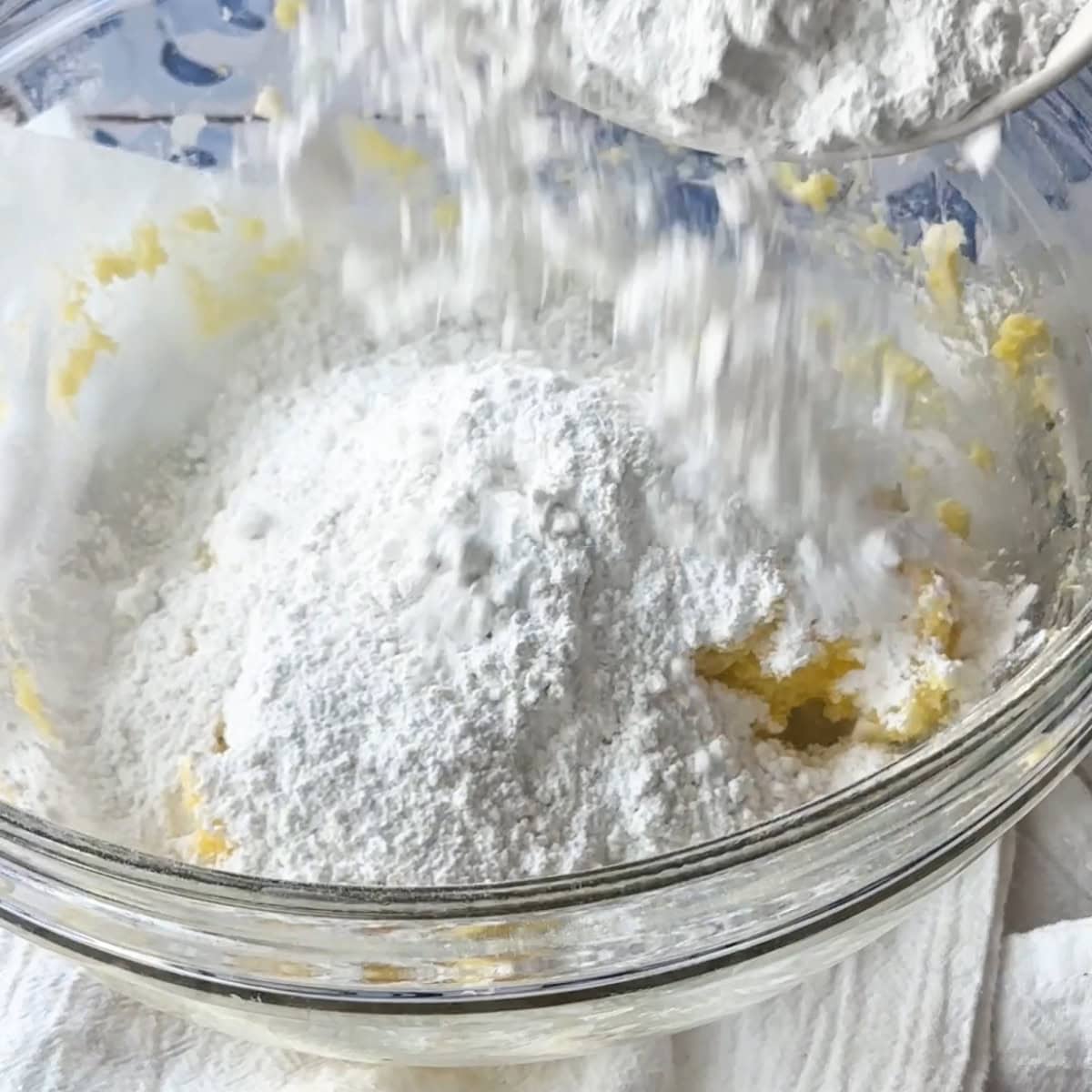 adding flour to the large bowl over the butter mixture to knead them