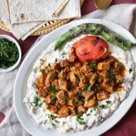 Ali Nazik served on a plate with a creamy eggplant and yogurt base, topped with tender spiced lamb and fresh parsley, ready to enjoy with flatbread.