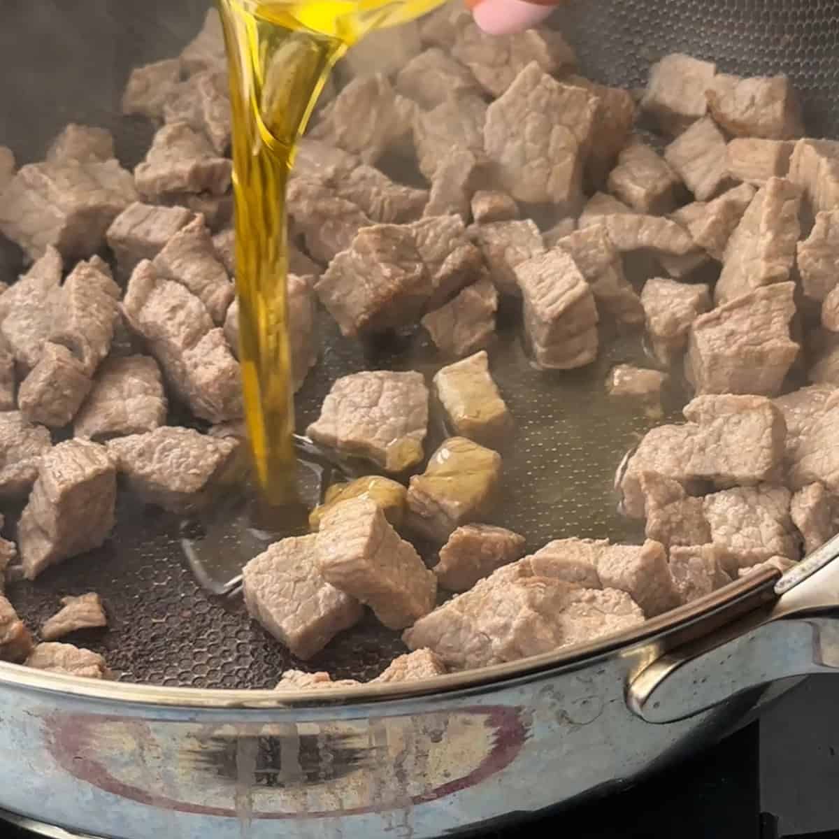 Adding olive oil to the cooked meat