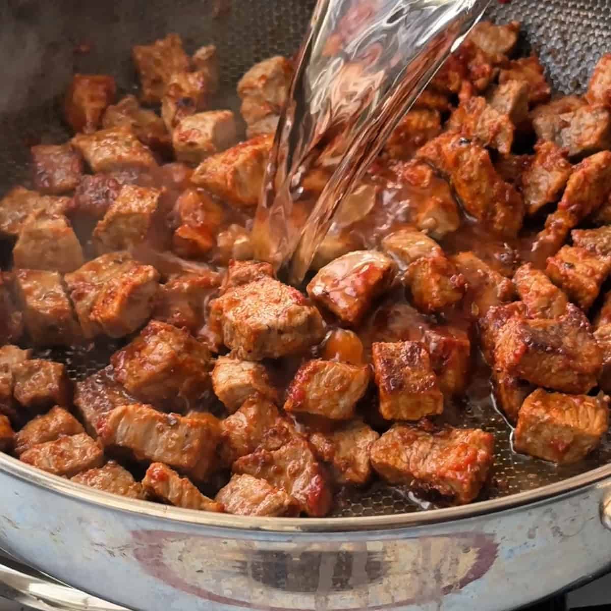 adding water to the cooked beef