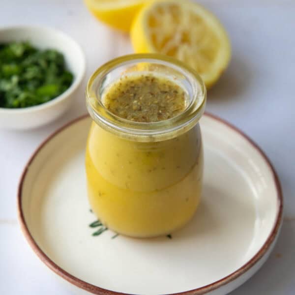 a shot of a mason jar with Mediterranean salad dressing placed on a plate