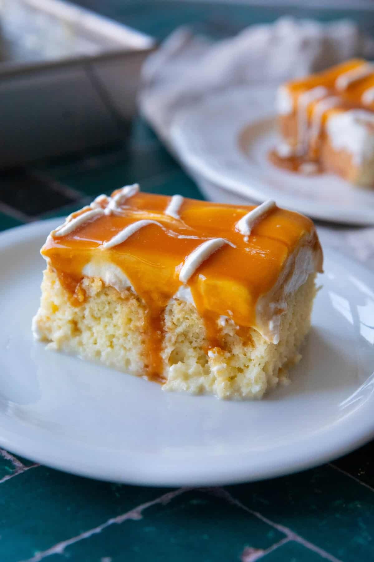 Turkish Milk Cake Recipe • Slice of Turkish Trilece cake topped with caramel on a white plate.