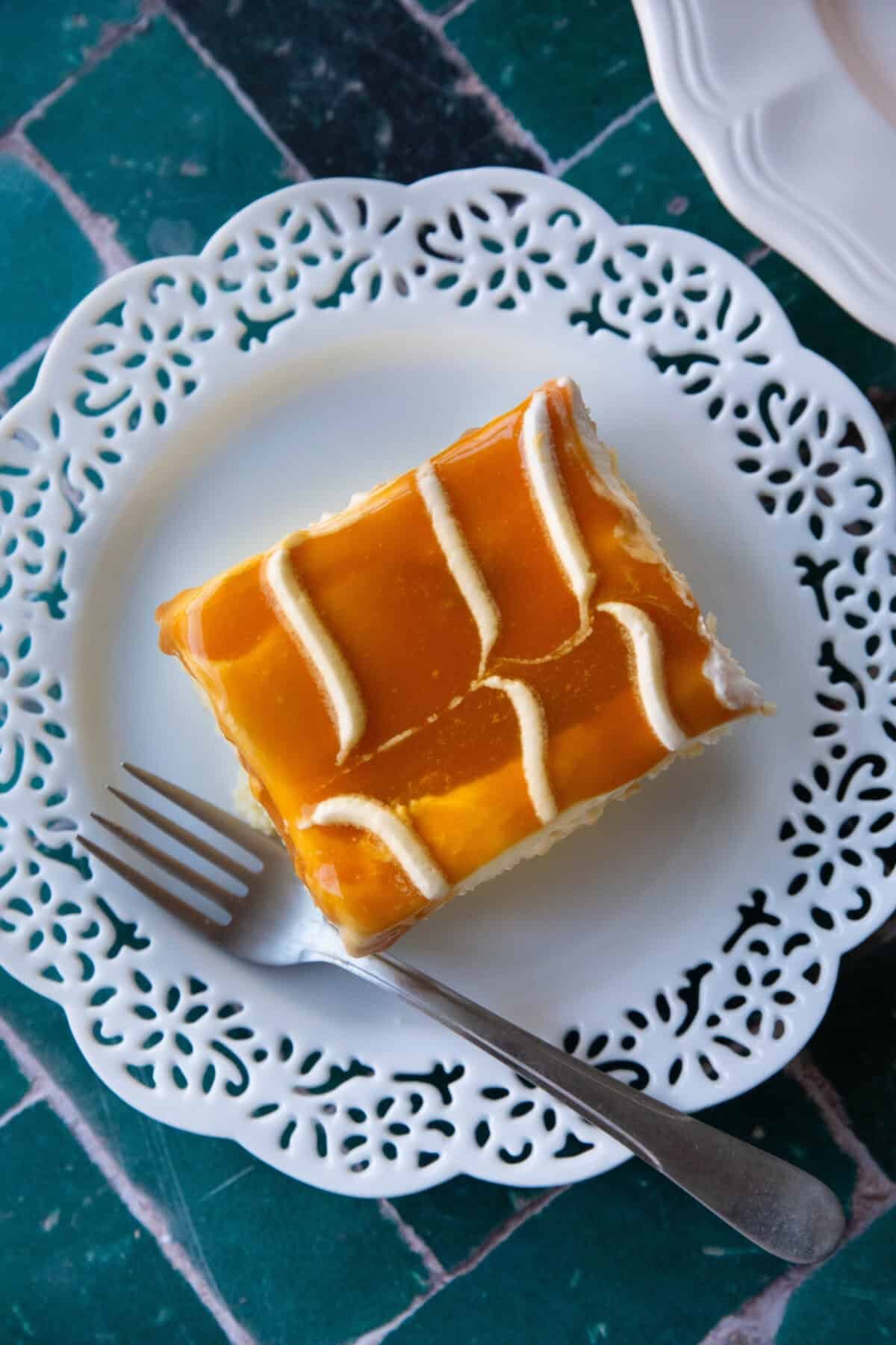 Trileçe A square piece of Trilece, Turkish milk cake, topped with caramel sauce, served on a white plate.