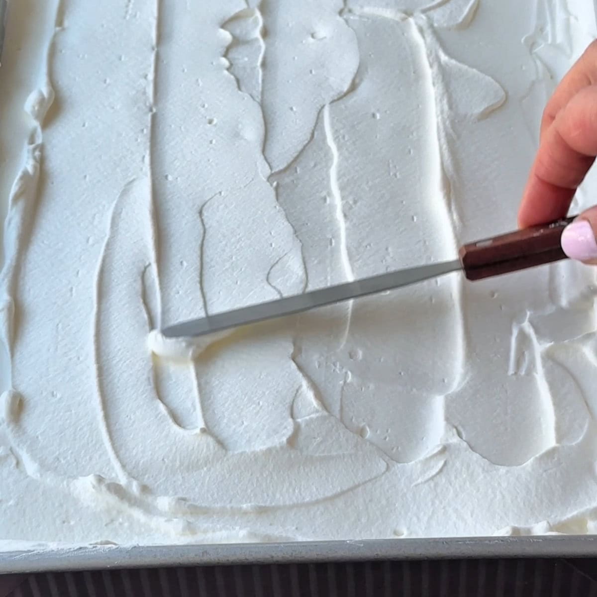 spreading the whipped cream using a spatula