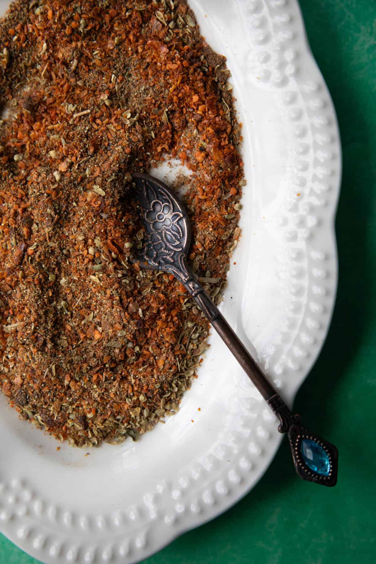Turkish Spice Blend Recipe a top shot of Turkish spice blend in a platter with a metal teaspoon
