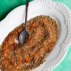 a top shot of Turkish spice blend in a platter with a metal teaspoon