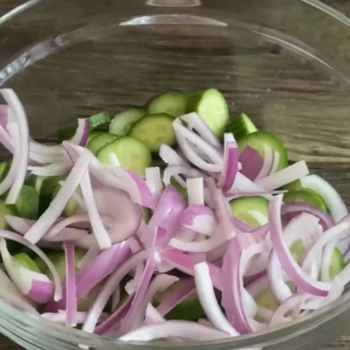 Chopped onion and cucumber in a bowl.