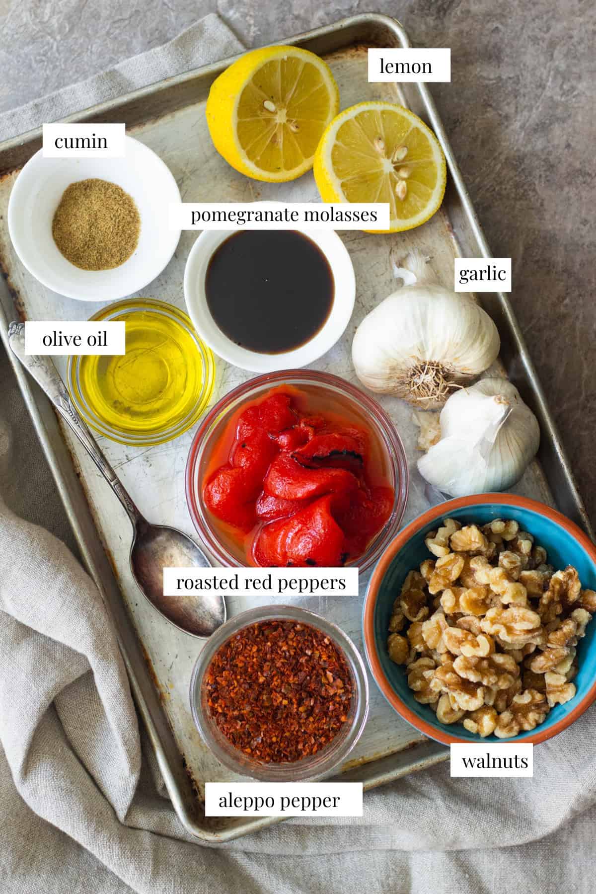 Muhammara Ingredients are cumin, pomegranate molasses, lemon, garlic, olive oil, roasted red peppers, walnuts and Aleppo pepper