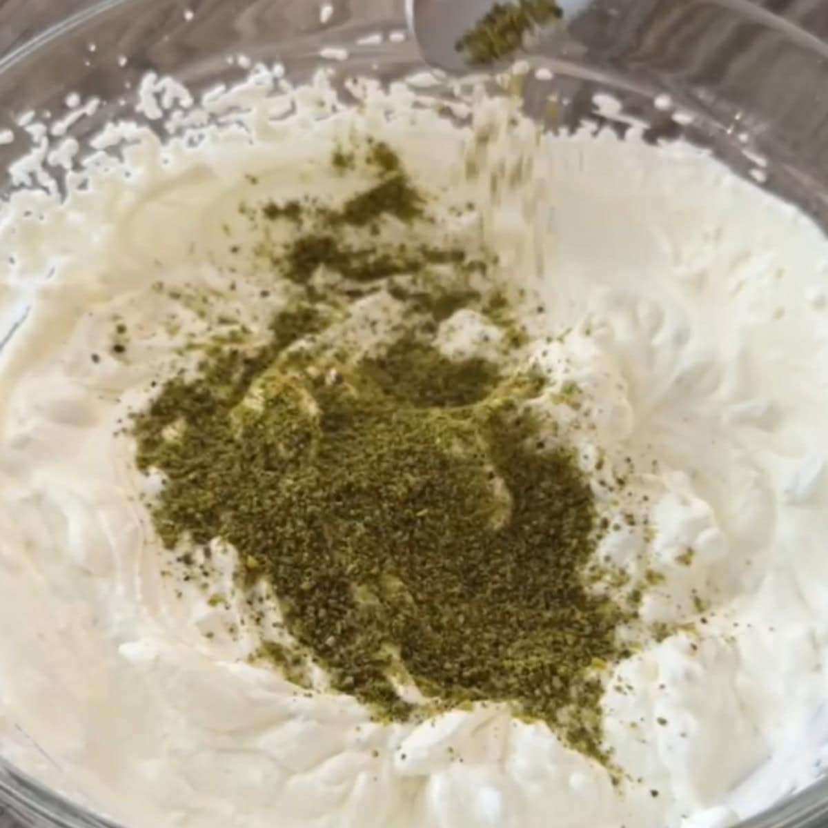 Add ground pistachios to the whipped cream.