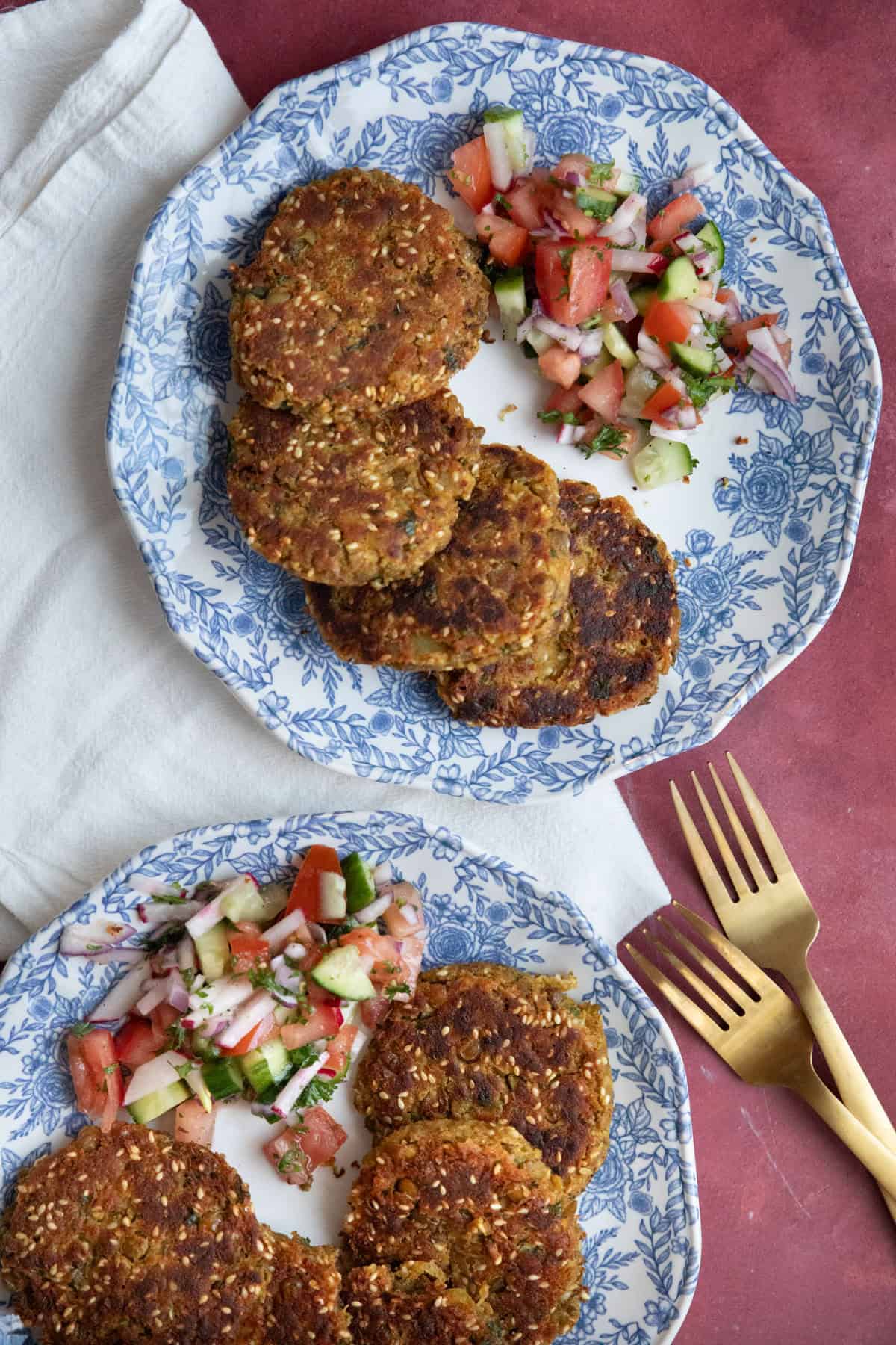 Crispy Mediterranean lentil fritters on plates with salad. 