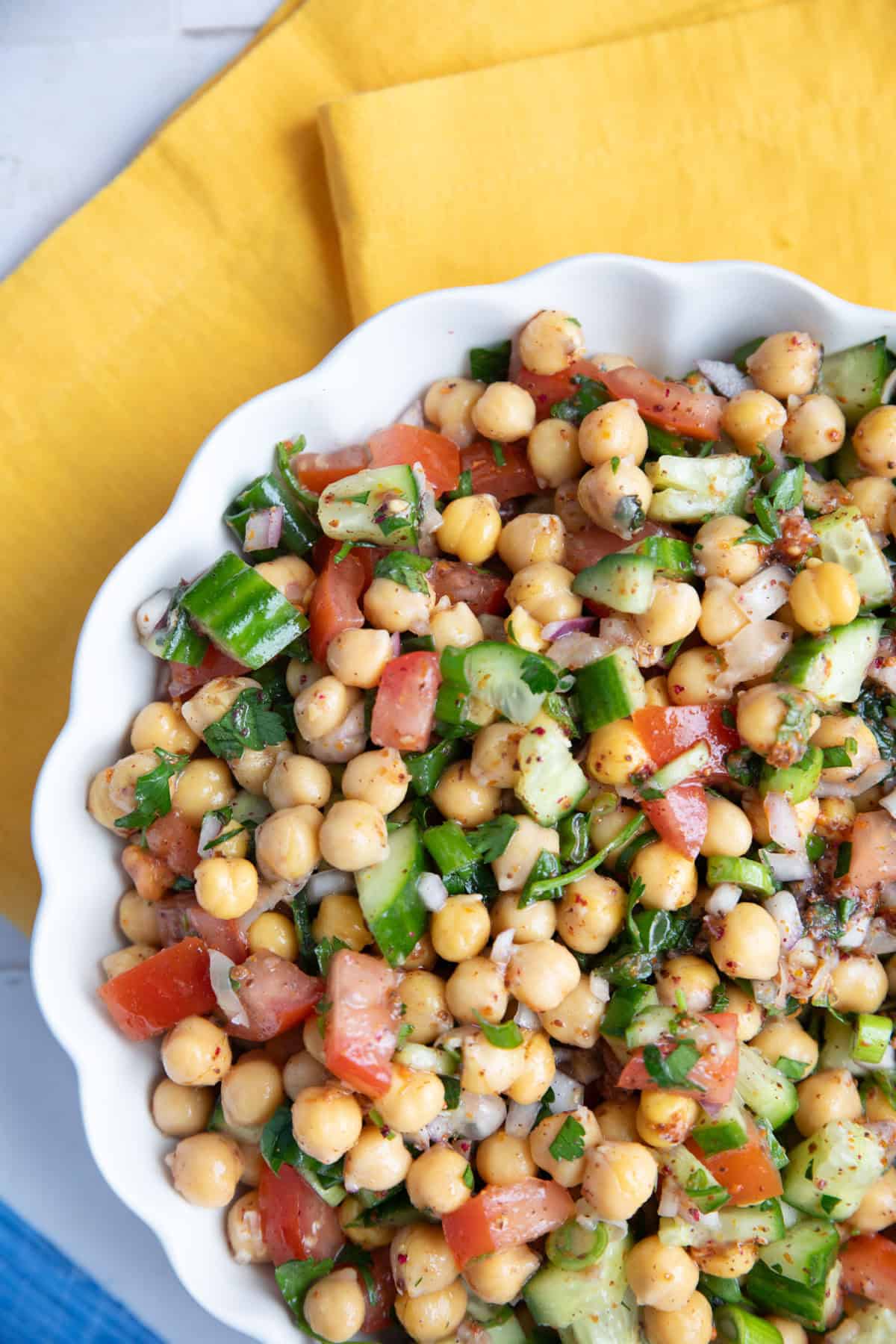 Middle eastern chickpea salad called balela served in a white bowl.