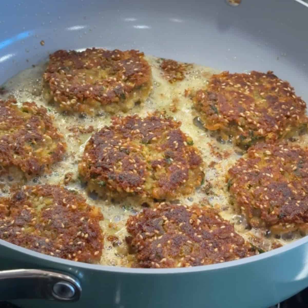 Fry lentil fritters until golden. 