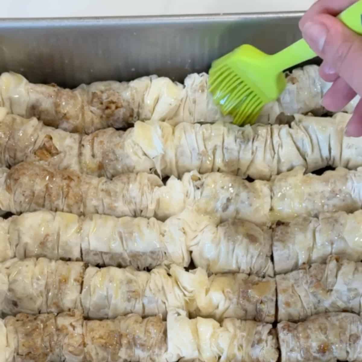 Brush the baklava with melted butter.