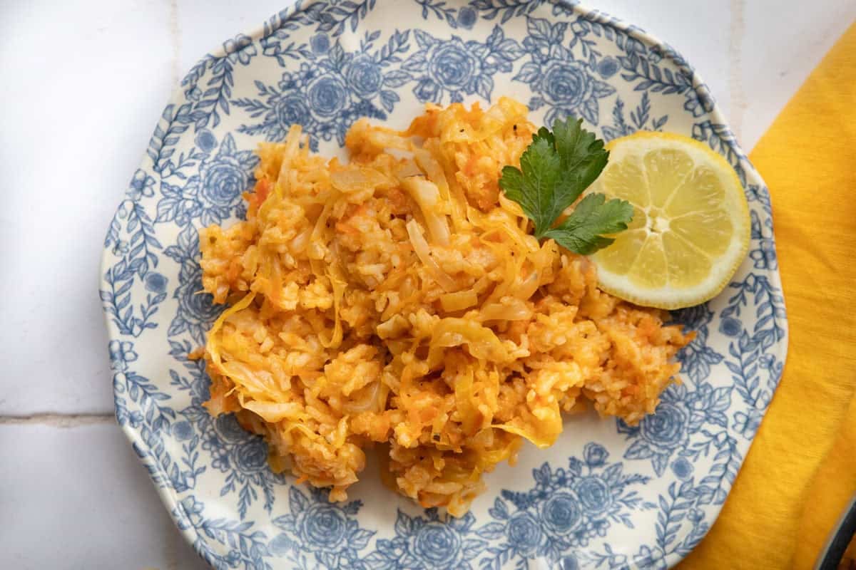 A plate of lahanorizo with lemon and parsley. 