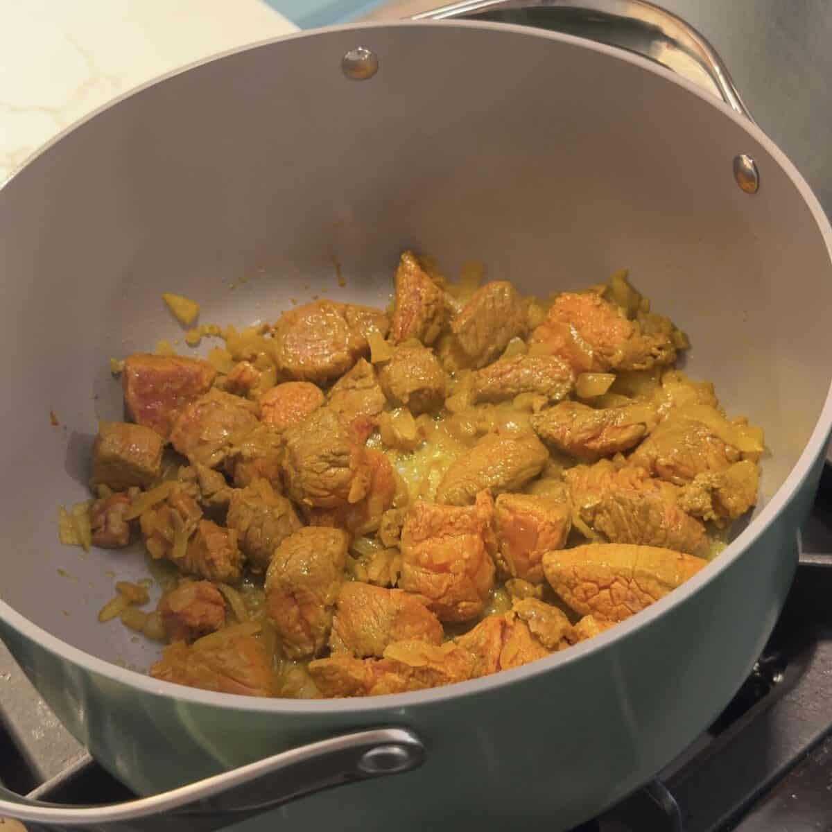 Add in the turmeric, salt and pepper to the lamb. 