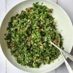 tabouli salad in a bowl with two spoons.