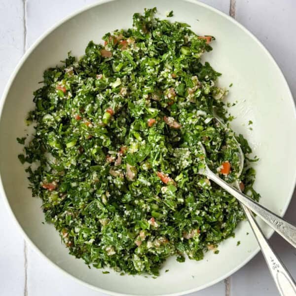 tabouli salad in a bowl with two spoons.