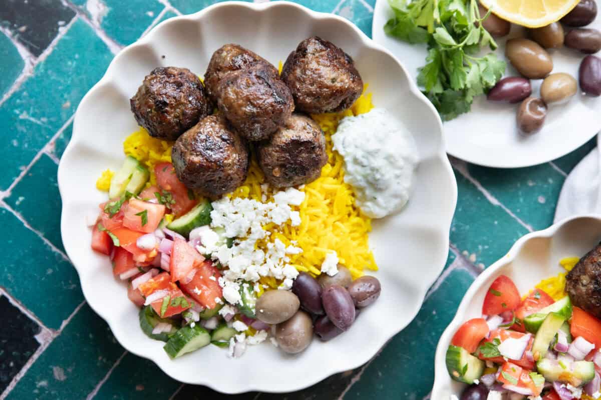 overhead shot of lamb meatballs in a bowl with yellow rice.