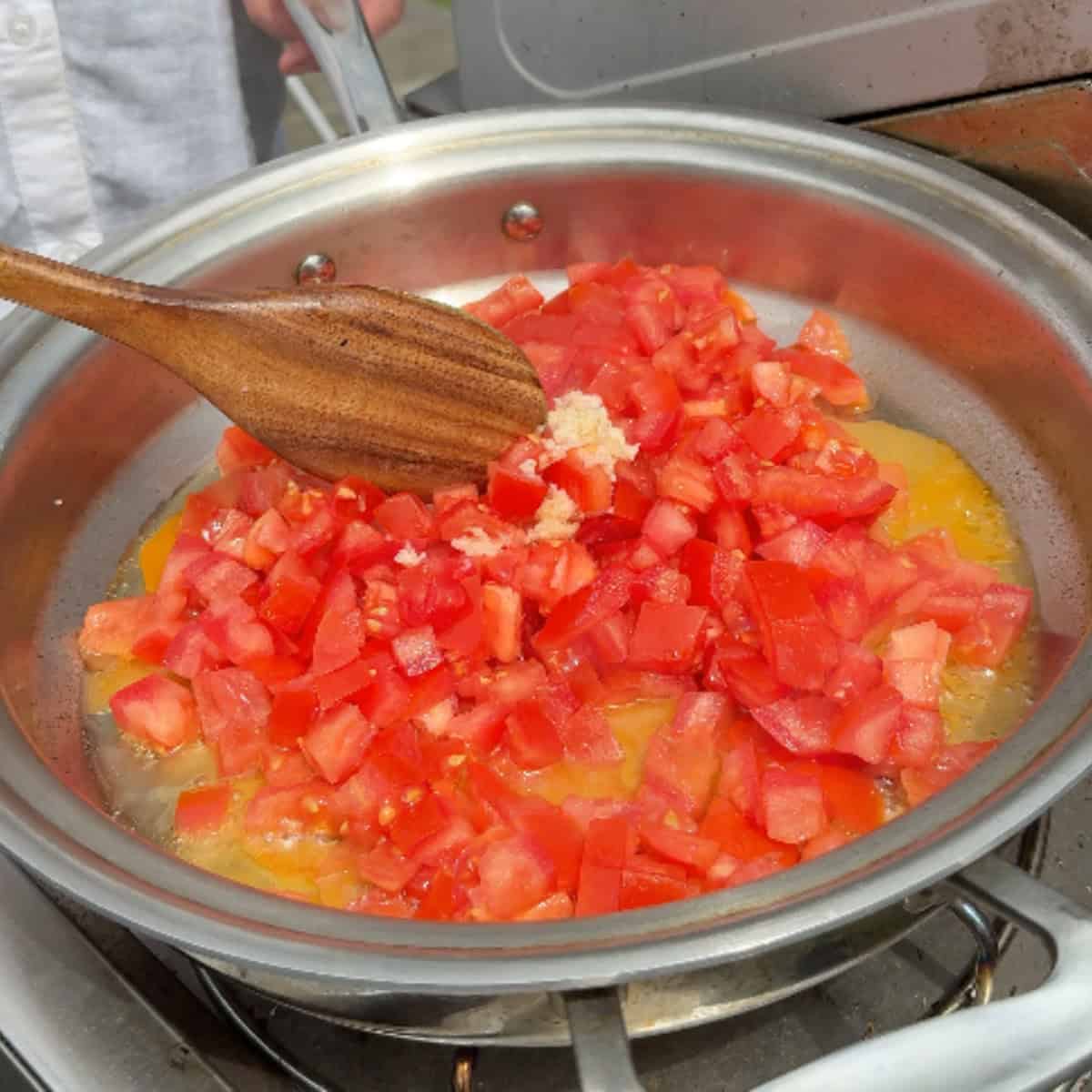 Sauté the tomatoes and garlic.