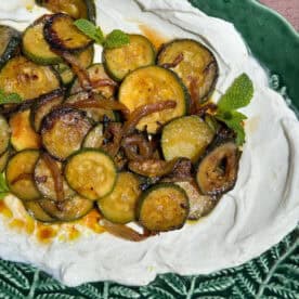 Sauteed zucchini with garlicky yogurt on a platter.